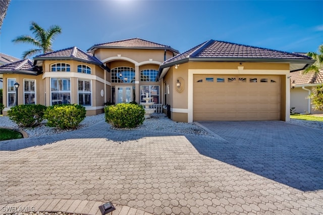 mediterranean / spanish home featuring french doors and a garage