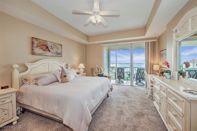 bedroom with ceiling fan, a raised ceiling, light carpet, and access to outside