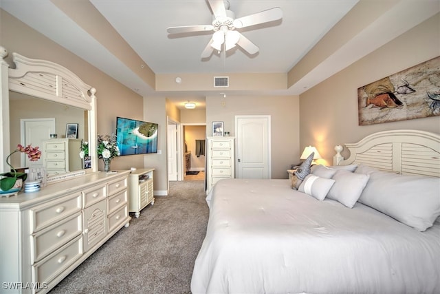 bedroom featuring a tray ceiling, ceiling fan, and carpet floors