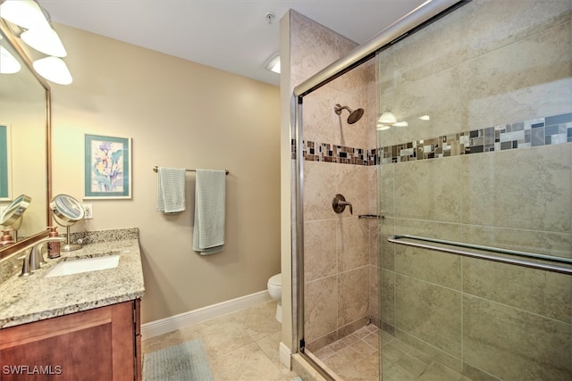 bathroom with tile patterned flooring, vanity, toilet, and an enclosed shower