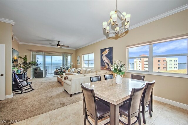 dining room with ceiling fan with notable chandelier, a water view, ornamental molding, and light tile patterned floors