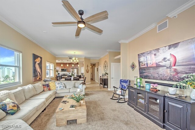 carpeted living room featuring ceiling fan with notable chandelier and ornamental molding