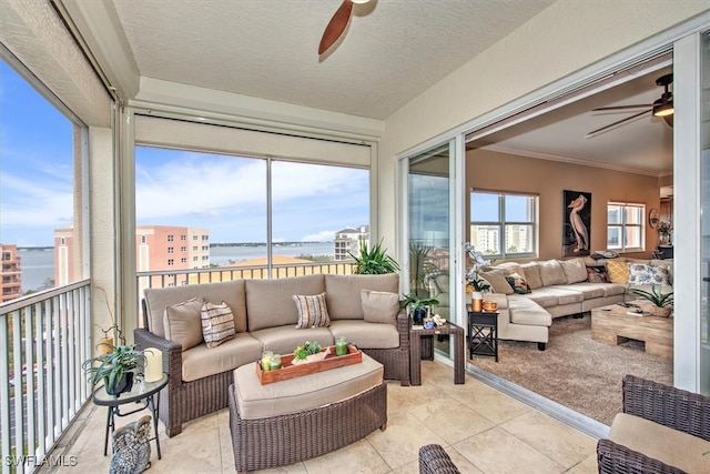 sunroom featuring a water view and ceiling fan