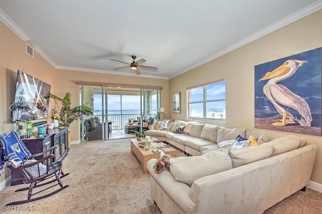 carpeted living room featuring ceiling fan, a water view, and ornamental molding