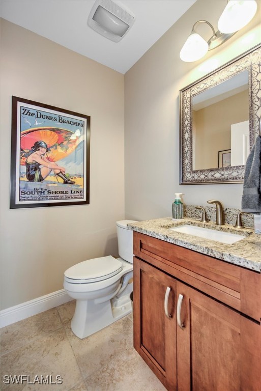 bathroom featuring tile patterned floors, vanity, and toilet