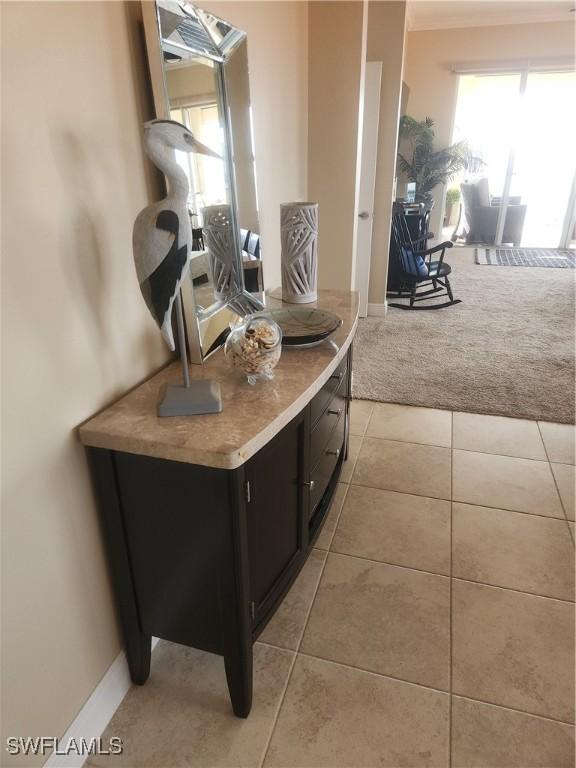 kitchen featuring light tile patterned floors, light colored carpet, light countertops, open floor plan, and dark cabinets