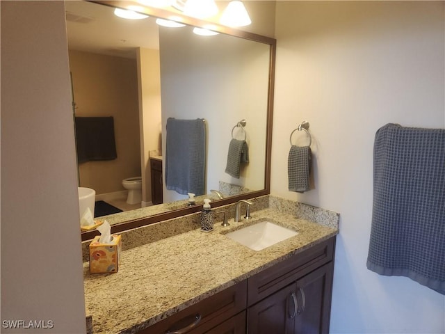 bathroom with toilet and vanity