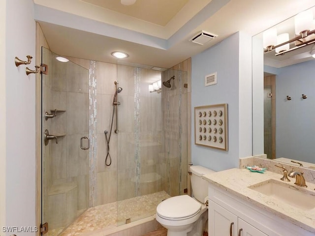 bathroom with vanity, a shower with shower door, and toilet