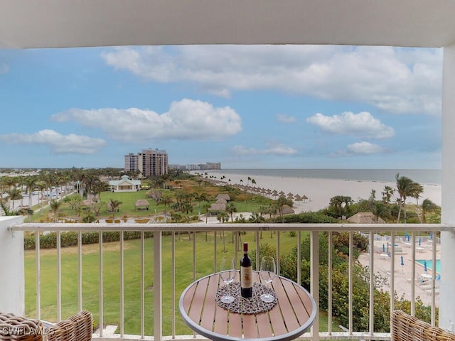 balcony with a water view and a view of the beach