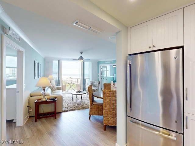 kitchen with white cabinetry, stainless steel fridge, ceiling fan, and light hardwood / wood-style floors