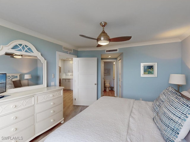 bedroom with ensuite bathroom, hardwood / wood-style floors, ceiling fan, and crown molding