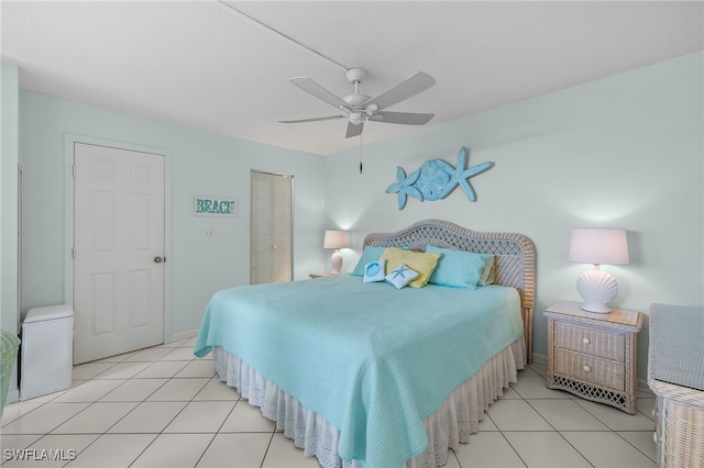 bedroom with ceiling fan, light tile patterned floors, and a closet