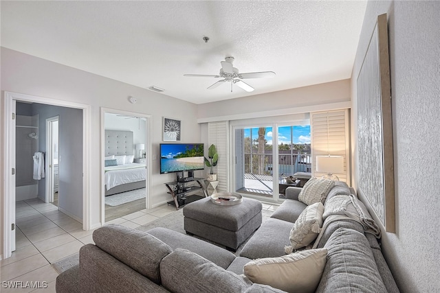 tiled living room with ceiling fan and a textured ceiling