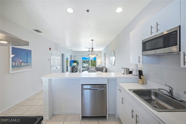 kitchen featuring kitchen peninsula, white cabinetry, hanging light fixtures, and an inviting chandelier