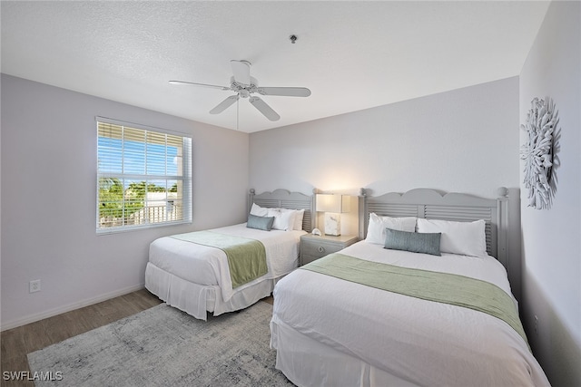 bedroom featuring ceiling fan, wood-type flooring, and a textured ceiling