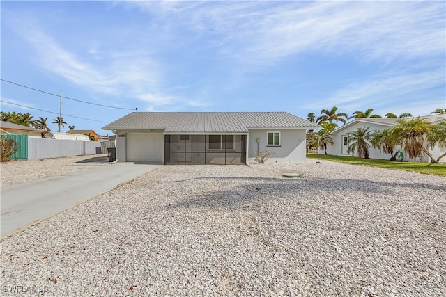 view of front of home with a sunroom and a garage