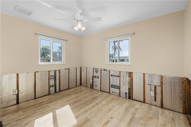 unfurnished room with plenty of natural light, ceiling fan, and light wood-type flooring