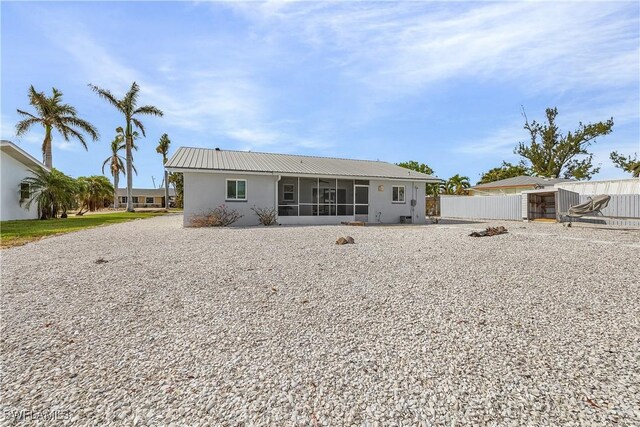 rear view of property featuring a sunroom