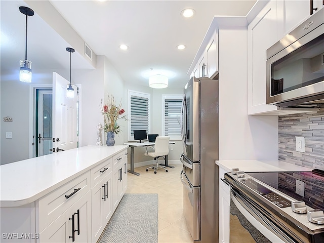 kitchen featuring backsplash, stainless steel appliances, white cabinetry, and hanging light fixtures