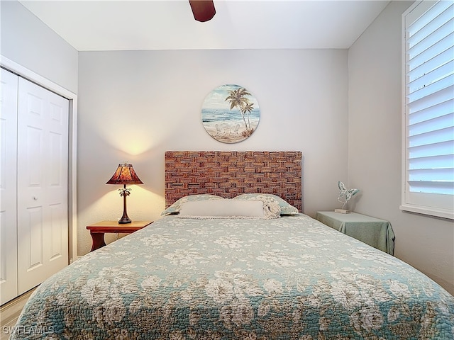 bedroom featuring multiple windows, ceiling fan, a closet, and hardwood / wood-style flooring