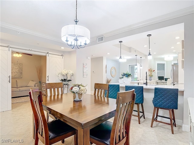 tiled dining space featuring a barn door, crown molding, and a chandelier