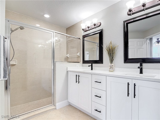 bathroom featuring vanity, a textured ceiling, tile patterned floors, and an enclosed shower