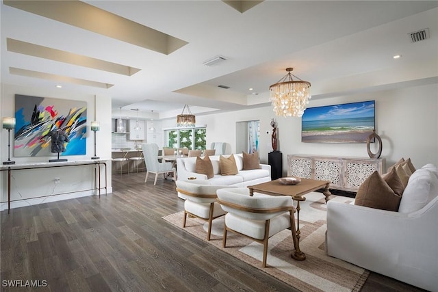 living room with dark hardwood / wood-style flooring and a notable chandelier