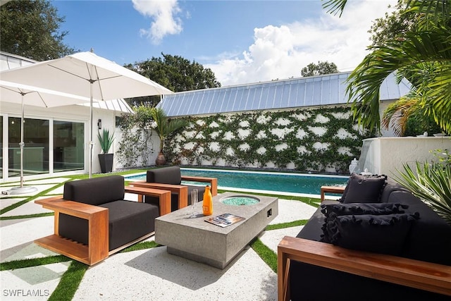 view of patio with an outdoor living space with a fire pit