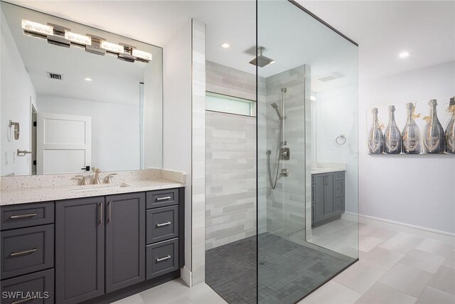 bathroom with a tile shower and vanity