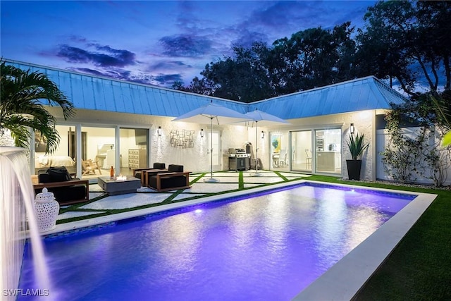 pool at dusk featuring an outdoor hangout area and a patio