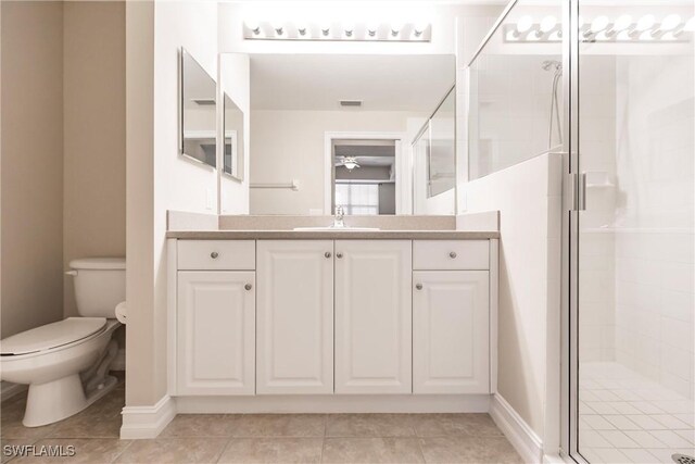 bathroom with tile patterned flooring, vanity, toilet, and an enclosed shower