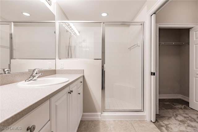 bathroom with tile patterned floors, vanity, and a shower with shower door