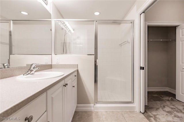 bathroom featuring vanity, tile patterned floors, and a shower with door