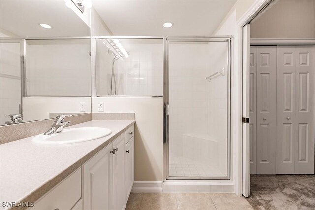 bathroom featuring vanity, tile patterned floors, and walk in shower