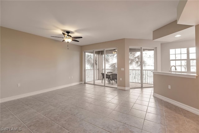 tiled spare room featuring ceiling fan