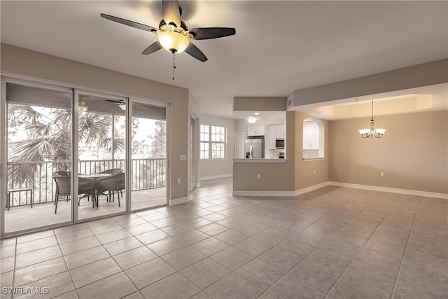 unfurnished living room with light tile patterned floors and ceiling fan with notable chandelier