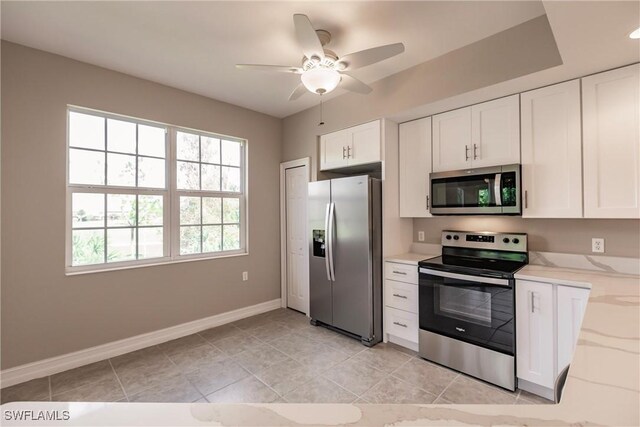 kitchen featuring white cabinetry, ceiling fan, light tile patterned floors, and appliances with stainless steel finishes