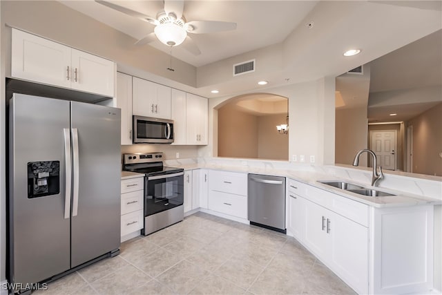 kitchen with ceiling fan with notable chandelier, sink, kitchen peninsula, white cabinetry, and stainless steel appliances