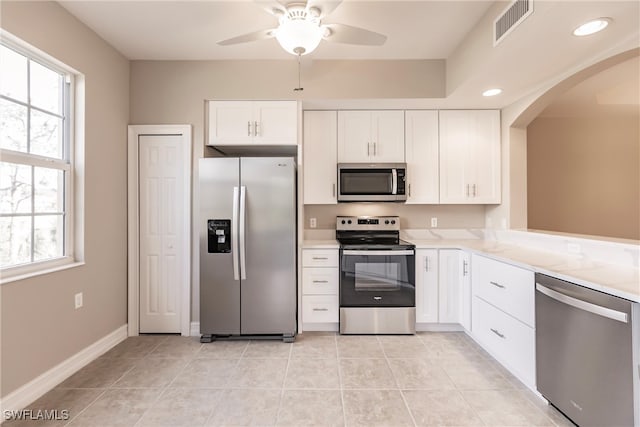 kitchen featuring ceiling fan, white cabinets, stainless steel appliances, and light tile patterned floors