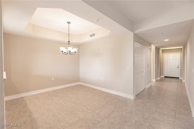 unfurnished room featuring a raised ceiling, light tile patterned floors, and an inviting chandelier