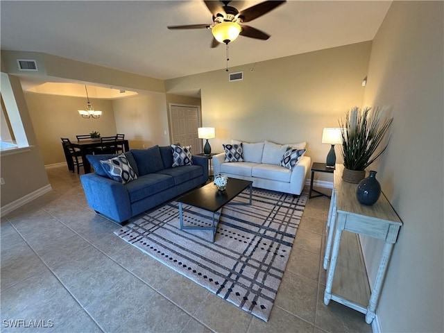 tiled living room featuring ceiling fan with notable chandelier