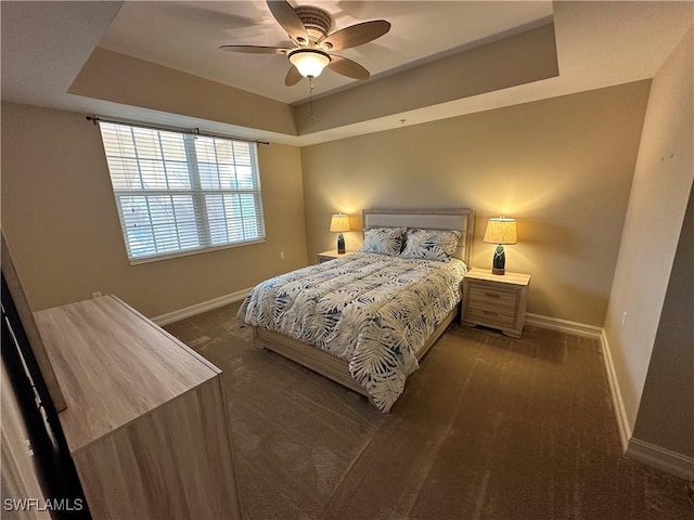 bedroom with ceiling fan and a raised ceiling