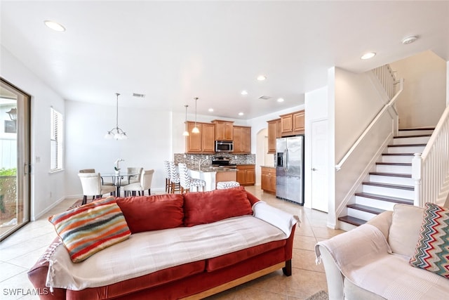 tiled living room featuring an inviting chandelier