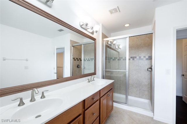 bathroom featuring tile patterned flooring, vanity, and a shower with door