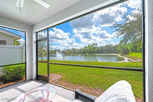 sunroom / solarium featuring ceiling fan and a water view