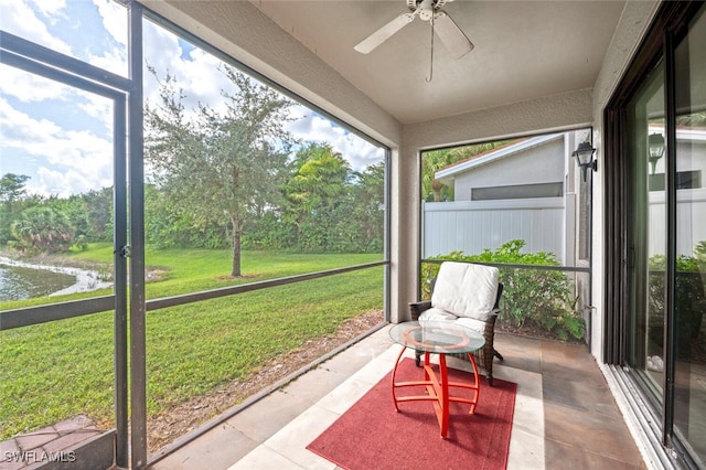 sunroom / solarium with a water view and ceiling fan