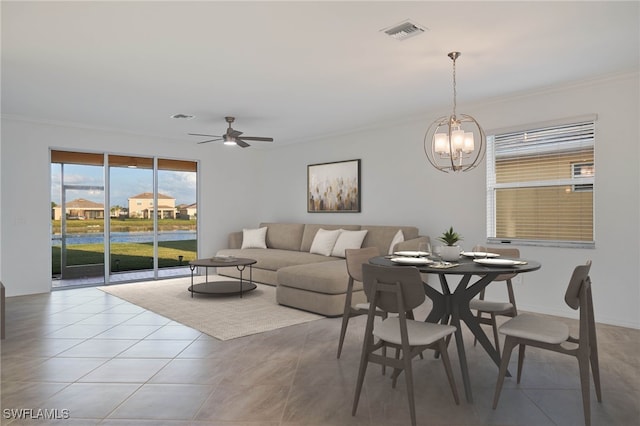 tiled dining area featuring ceiling fan with notable chandelier and crown molding