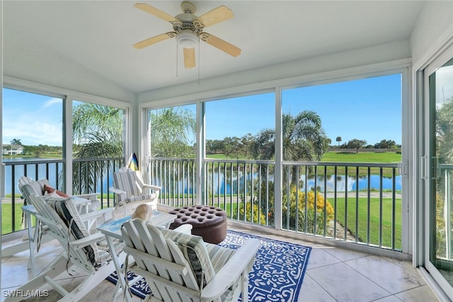 sunroom / solarium featuring ceiling fan, a water view, and vaulted ceiling