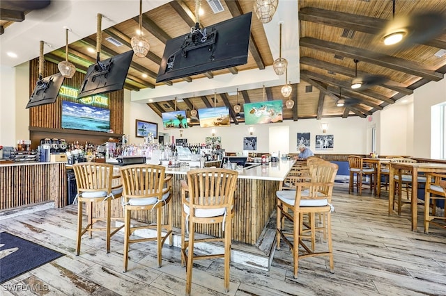 bar with lofted ceiling with beams, light hardwood / wood-style flooring, and wooden ceiling