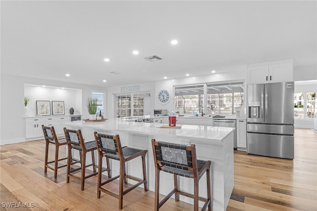 kitchen featuring recessed lighting, visible vents, white cabinetry, light wood-style floors, and appliances with stainless steel finishes